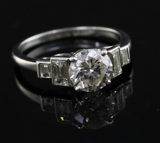 A platinum and single stone diamond ring with baguette cut diamond set stepped shoulders, size J.